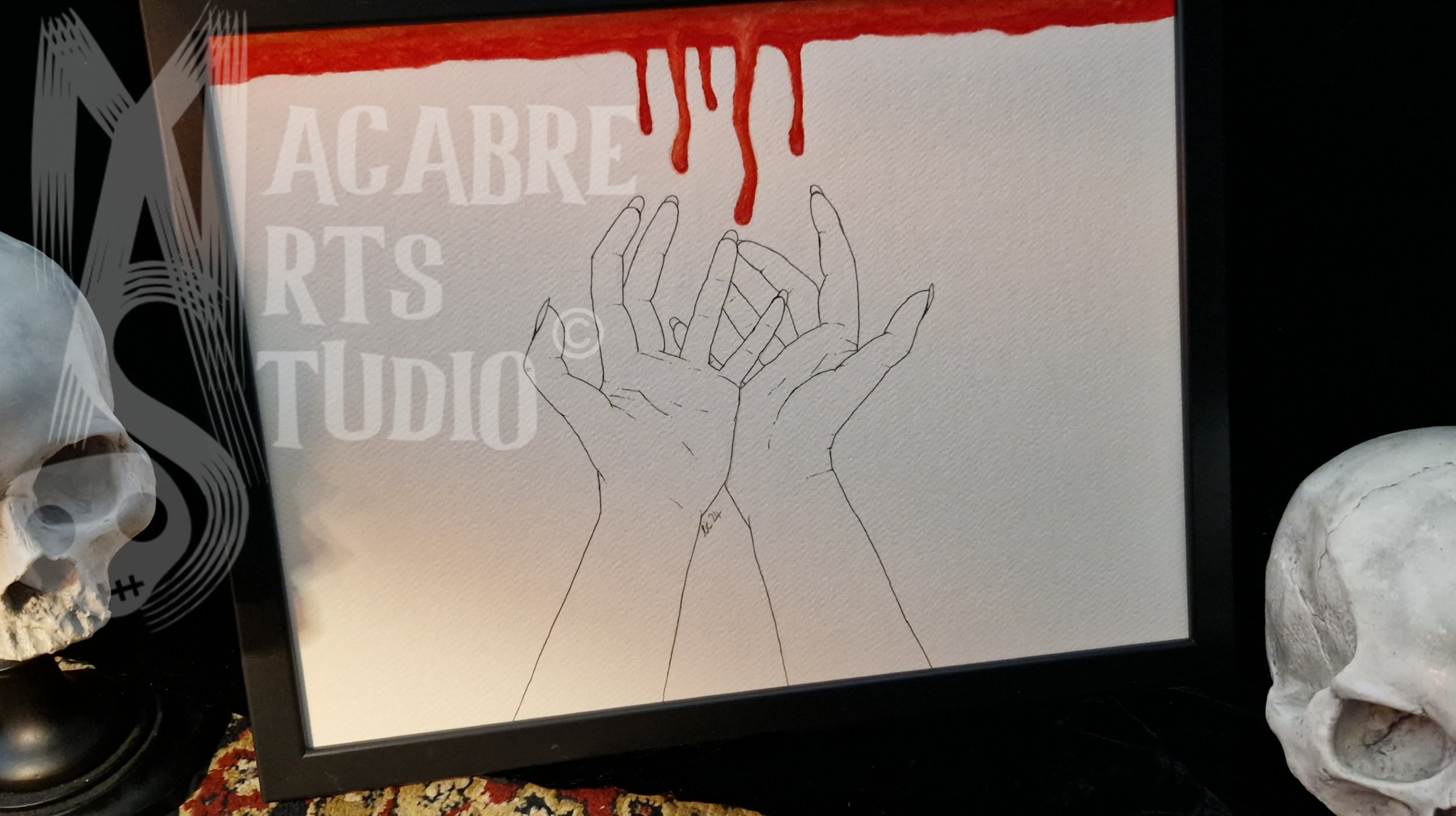 A framed artwork featuring a line drawing of hands reaching upward, with red dripping from the top. Overlaid with copyright watermark.