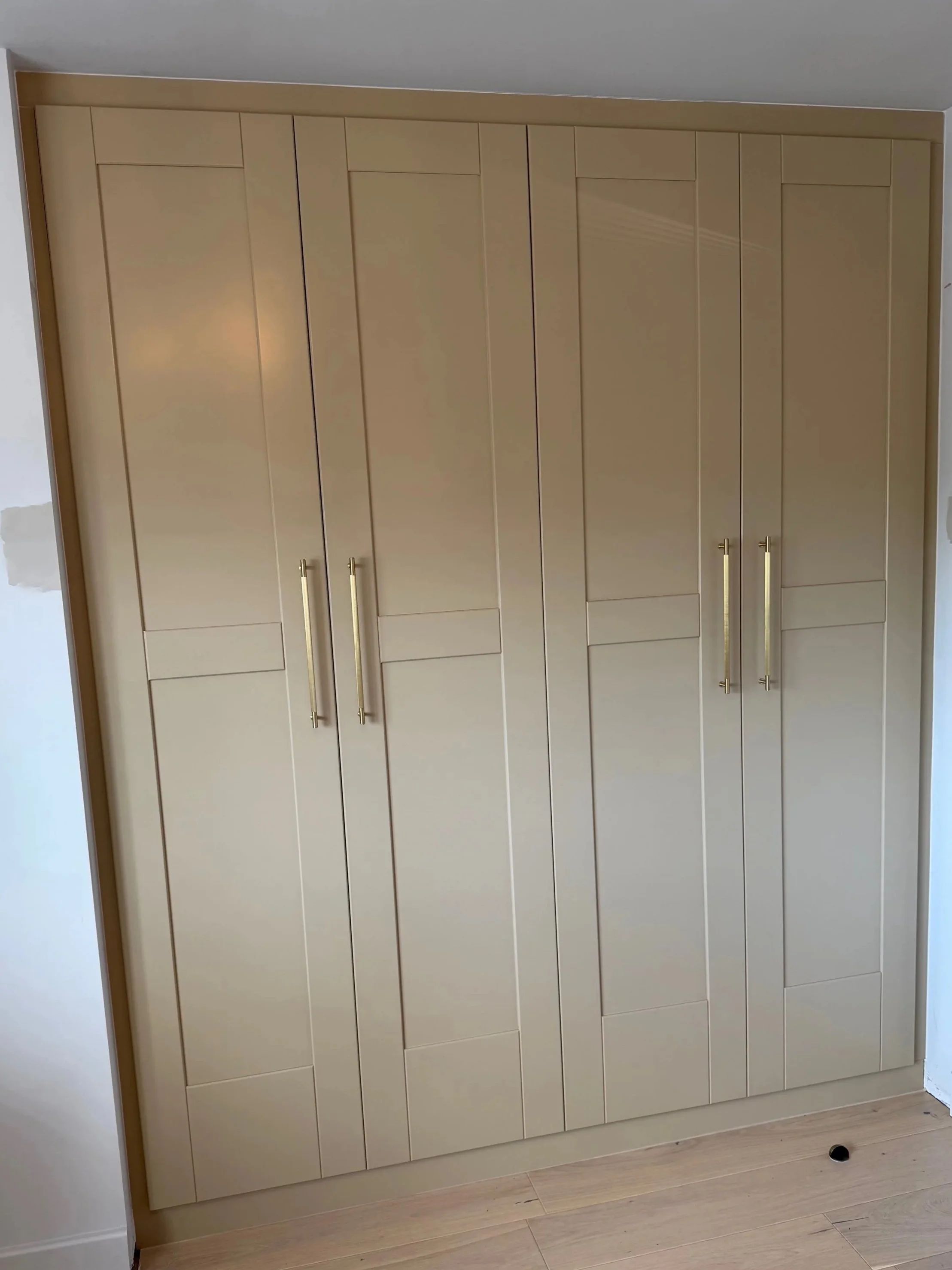 Twin double wardrobes created to perfectly fit the available space. Hand sprayed  in 'Lute' colour by Little Greene.