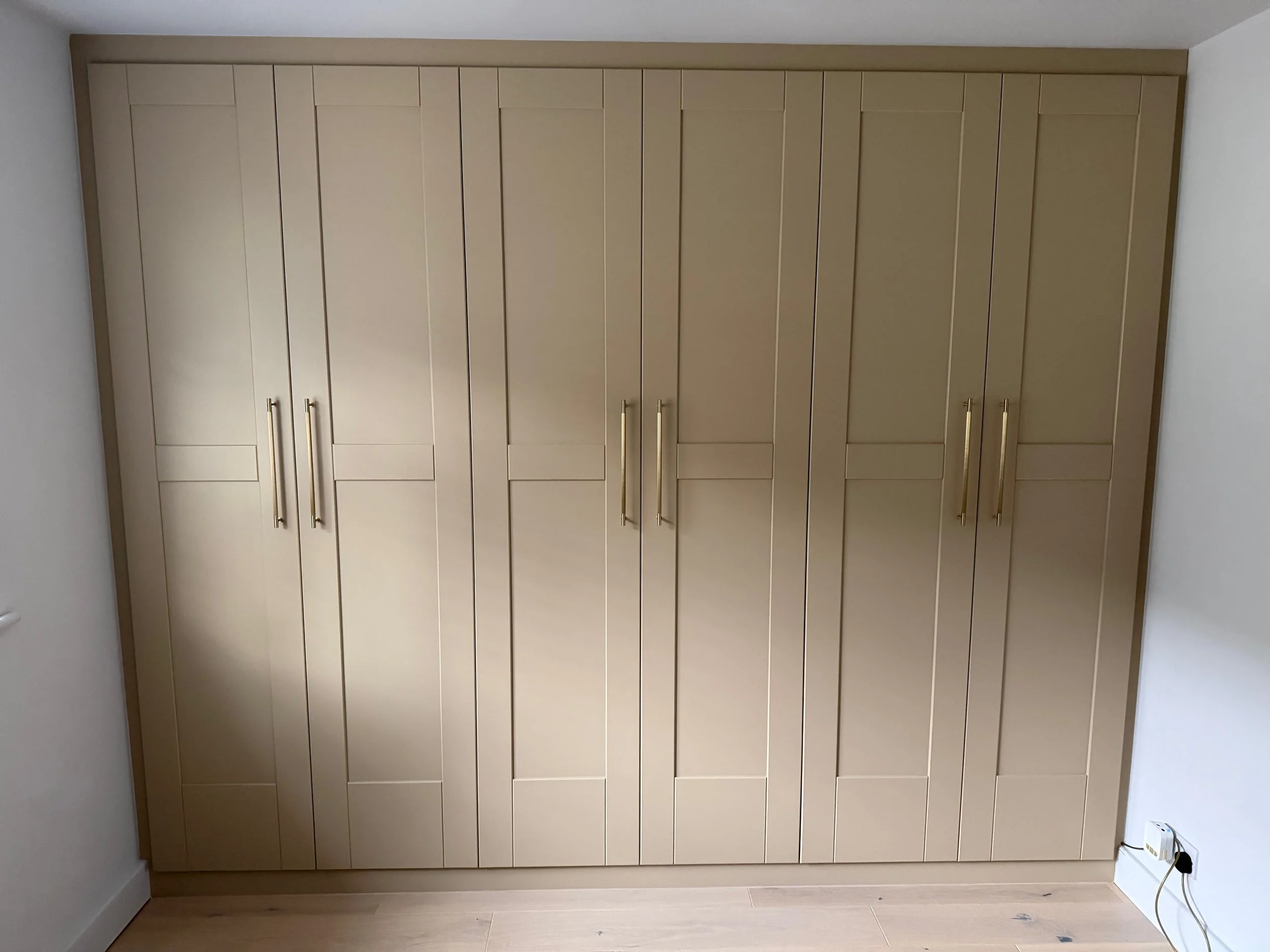 Bespoke bank of 3 double wardrobes. All doors and carcasses made by Broadstone Interiors and spray finished in matched  'Lute' by Little Greene. 