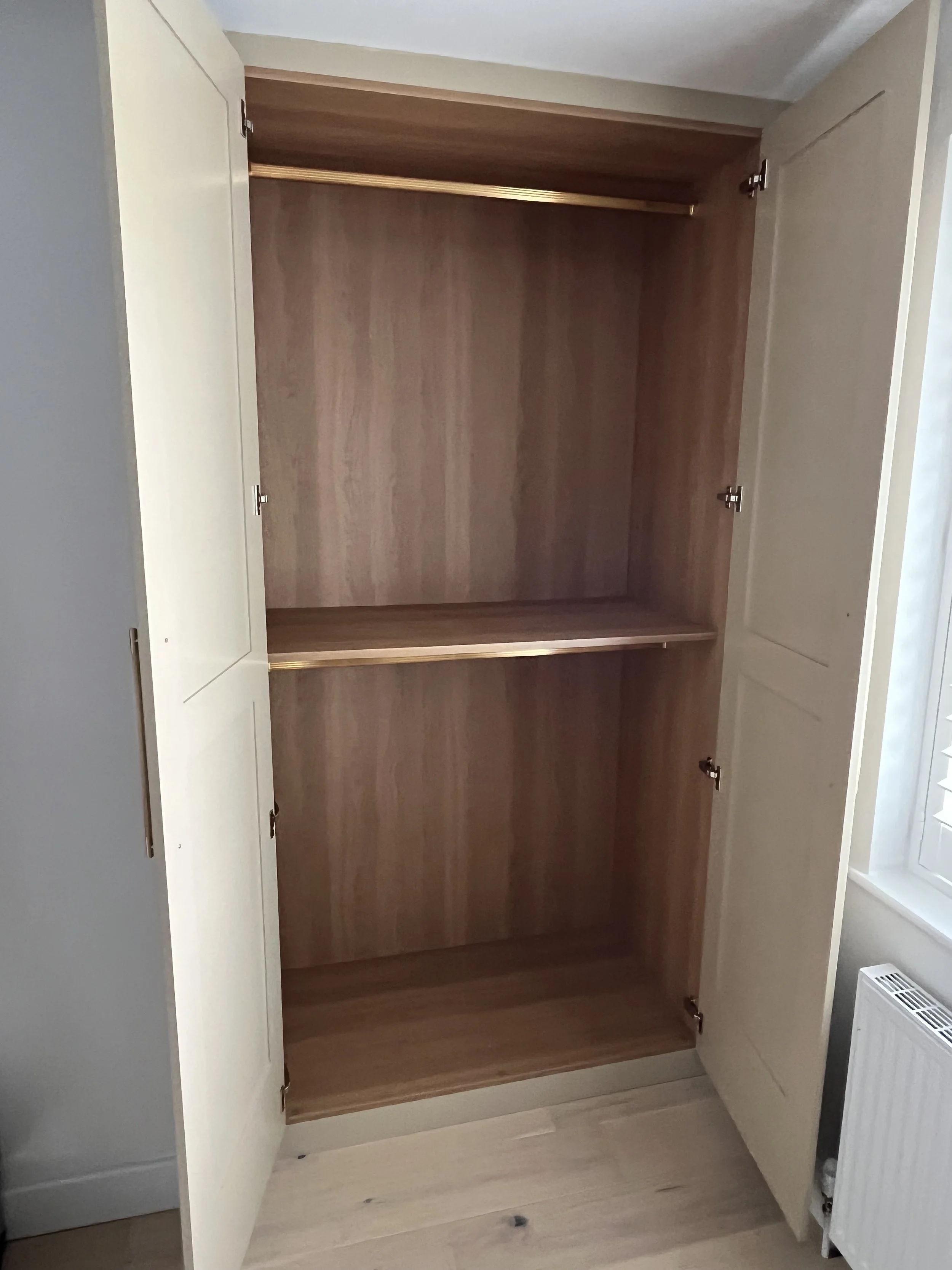 After - Bespoke Handcrafted and Spray Painted Fitted Wardrobe, with hand made Shaker Doors and Gold Handles - Carcass is Oak Effect  with brass Hanging Rail.