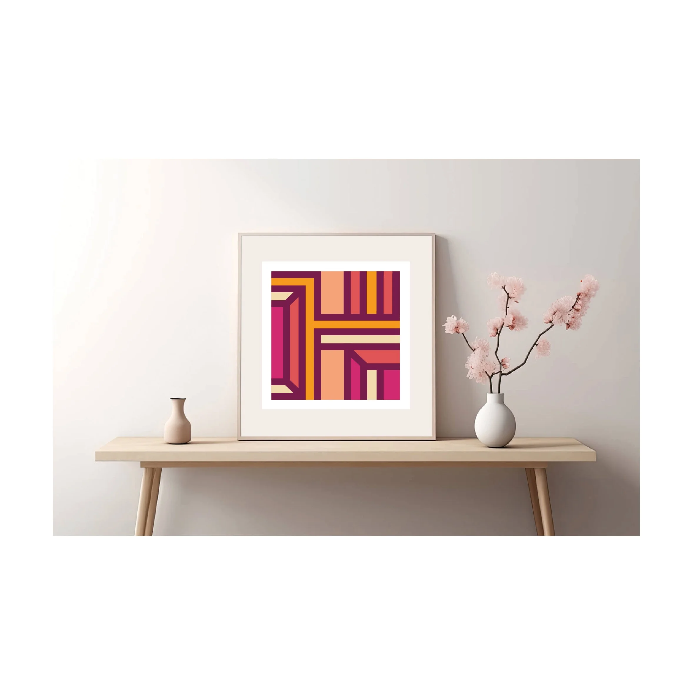 Contemporary geometric art print in pink, orange and burgundy tones  displayed in a light wood frame on a minimalist console table.