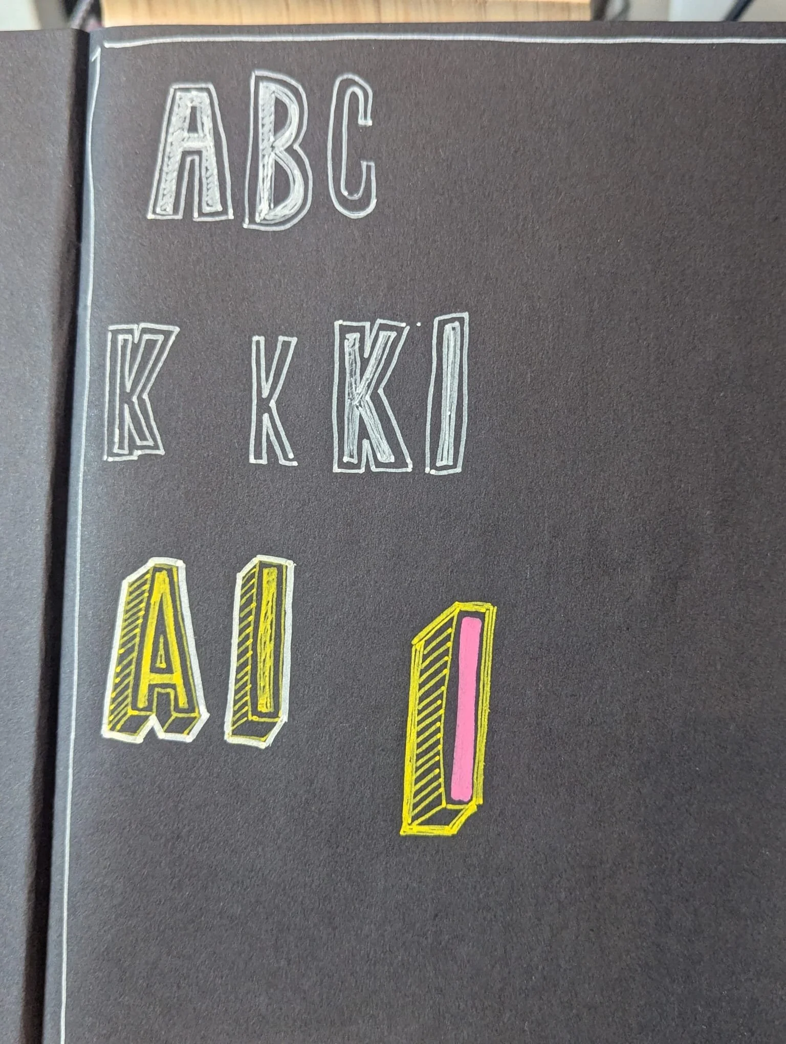 Close-up of a black background with colorful outlined text reading 'ABC' and 'KIK', where some letters are decorated with hatching and pink or yellow color accents.