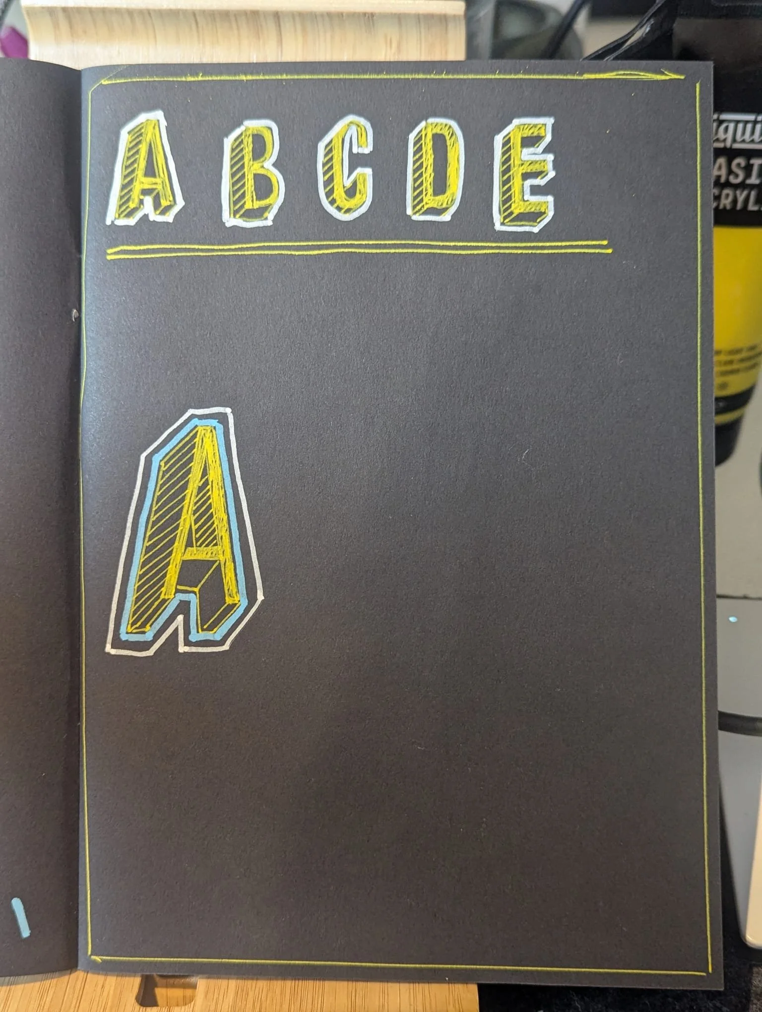 A black page with the alphabet A to E written in large, colorful, 3D block letters with yellow, white, and black outlines.