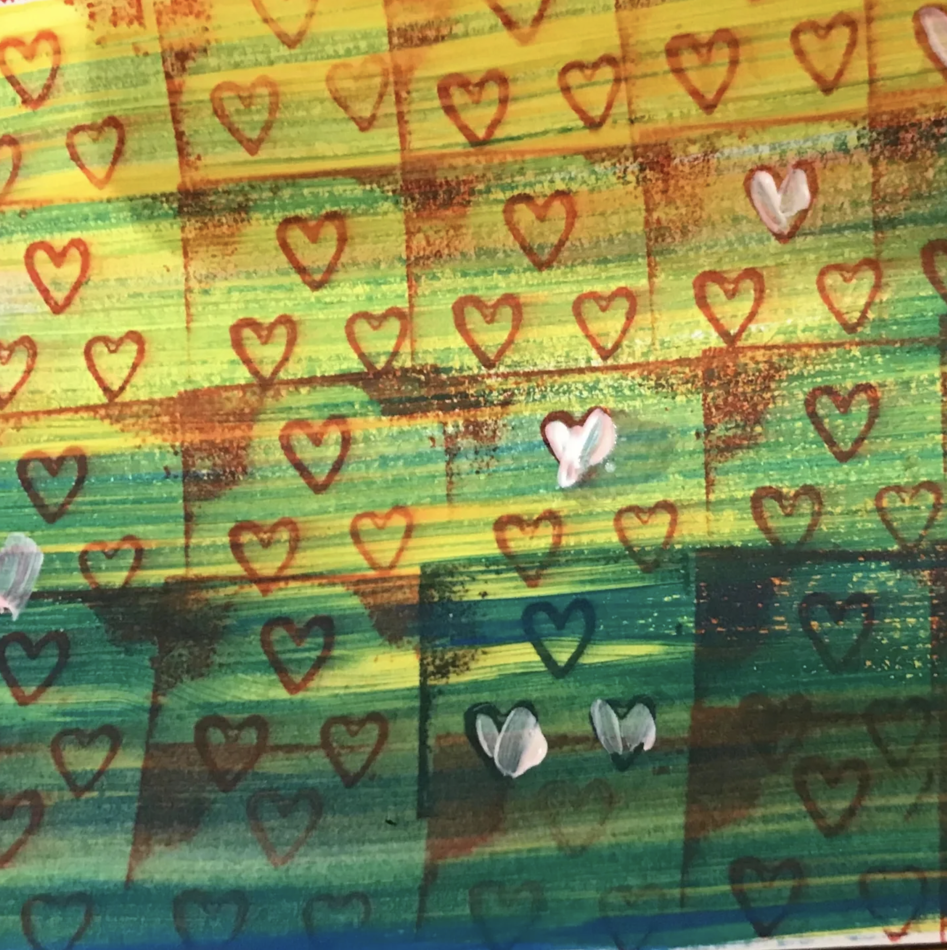 Colorful drawing featuring horizontal stripes in shades of green, yellow, and red, with numerous red and white hearts scattered throughout.