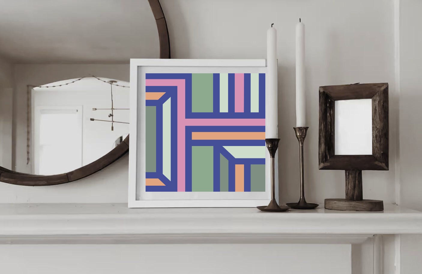 Contemporary geometric art print in olive green, orange and pink tones  displayed in a white wood frame on a shelf in a contemporary interior.