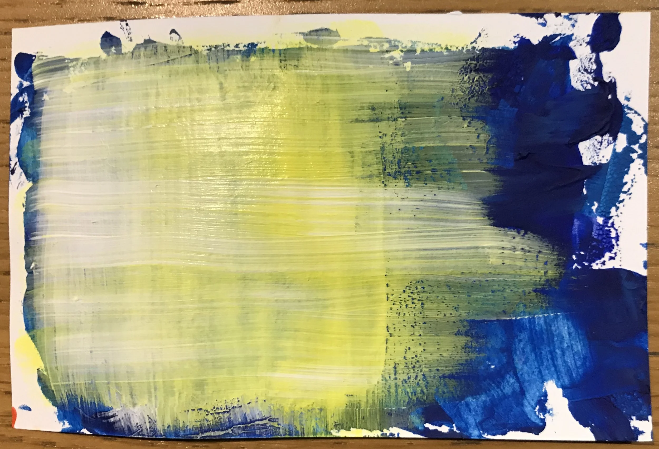 An abstract painting with yellow, green, and blue horizontal brushstrokes on white paper.