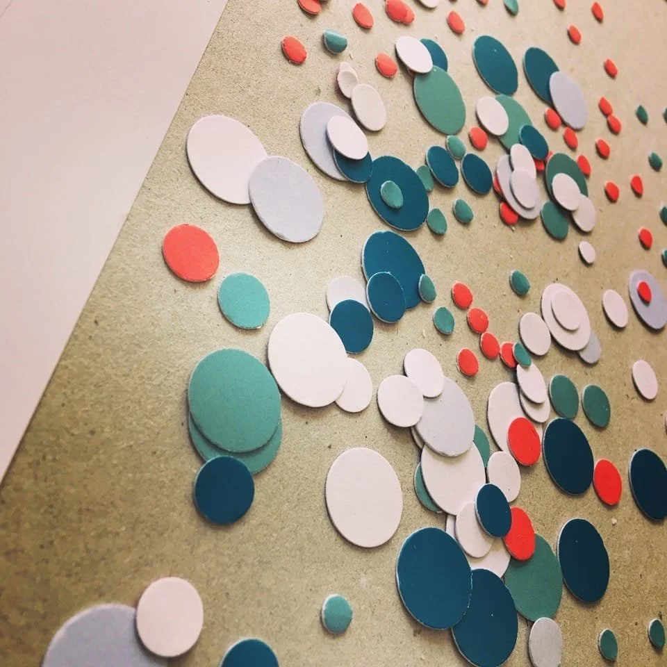 Colorful circle confetti scattered on a beige surface.