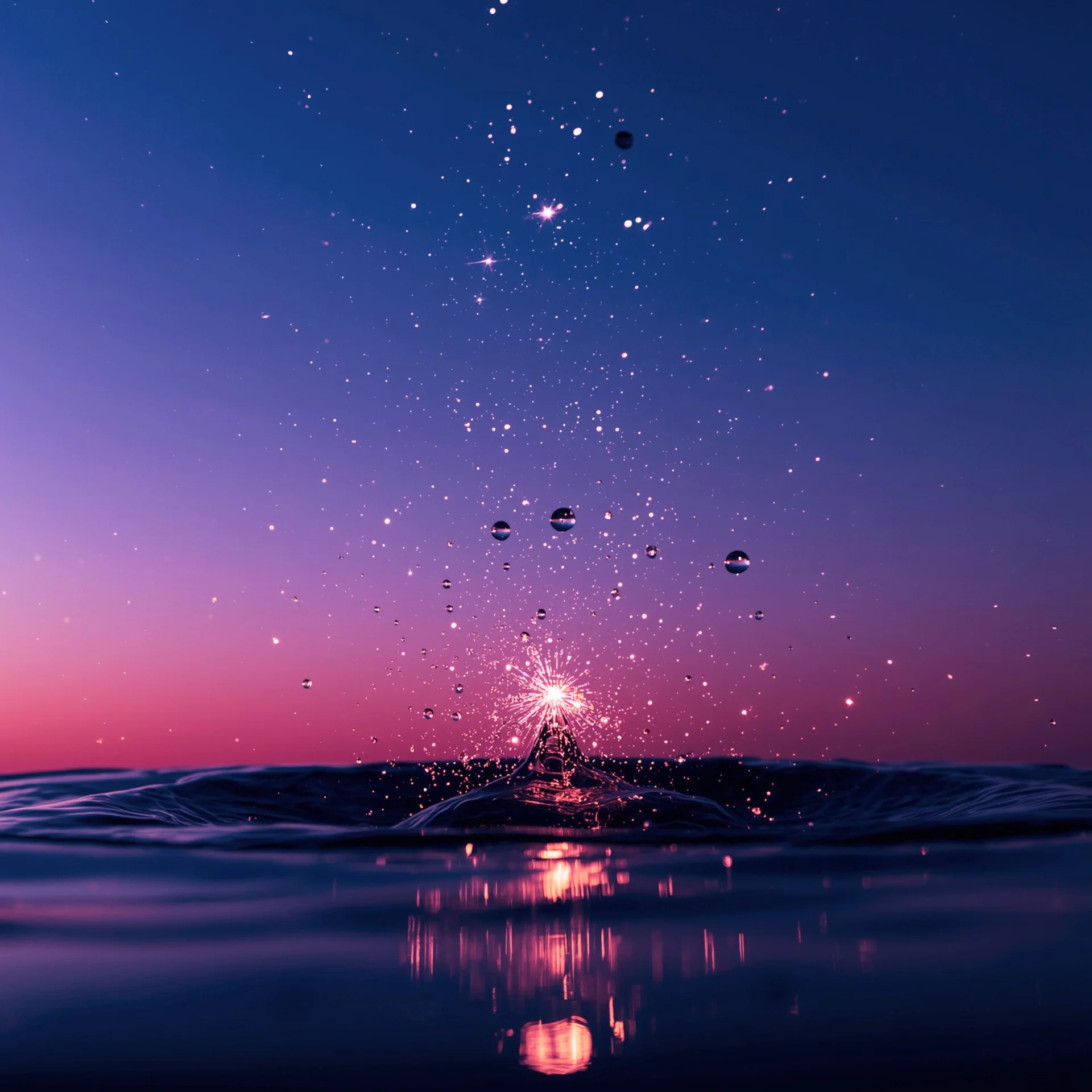 Feux d'artifice éclairant le ciel étoilé au-dessus de l'océan, avec des reflets lumineux sur l'eau.