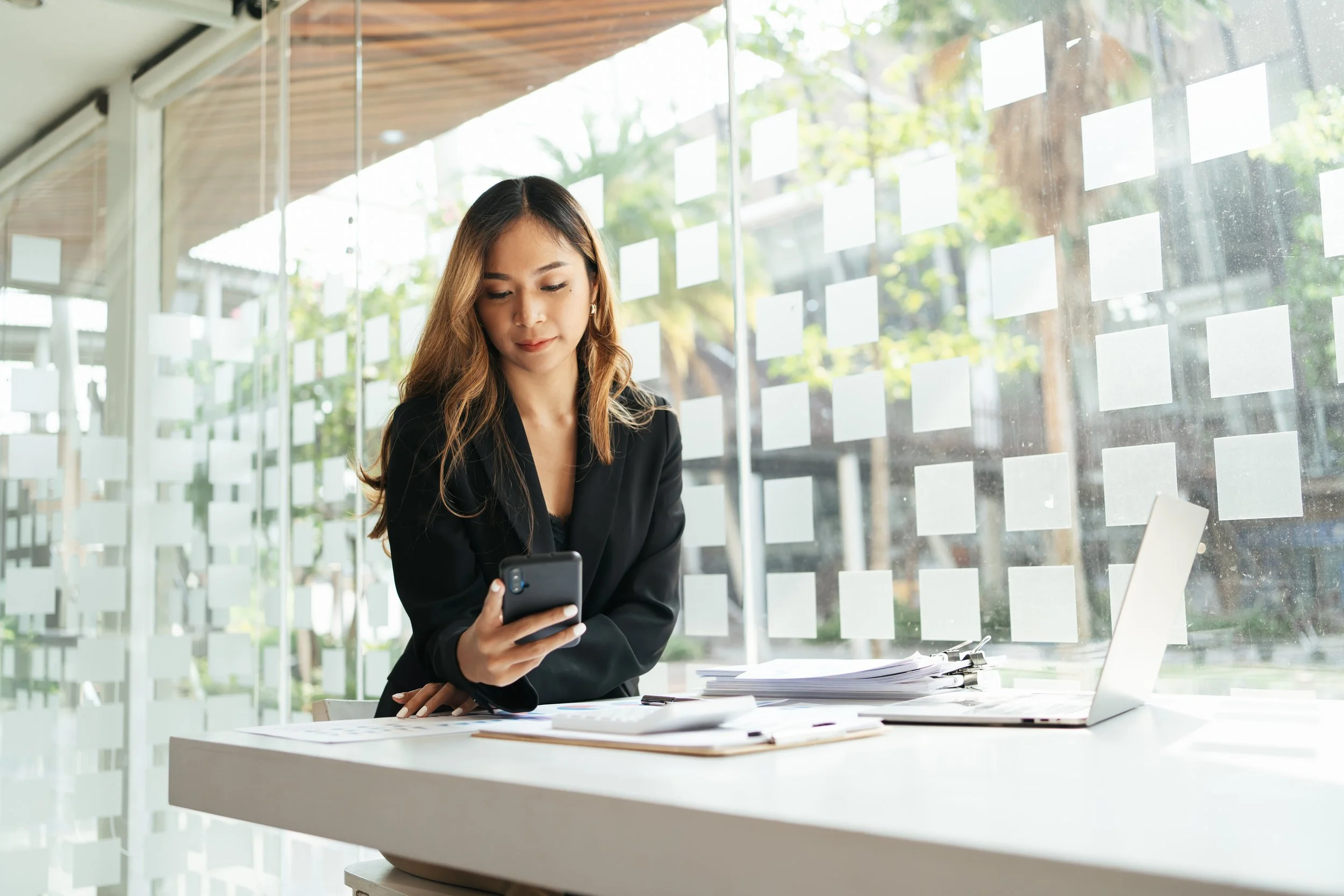 Young business woman looking at her cellphone