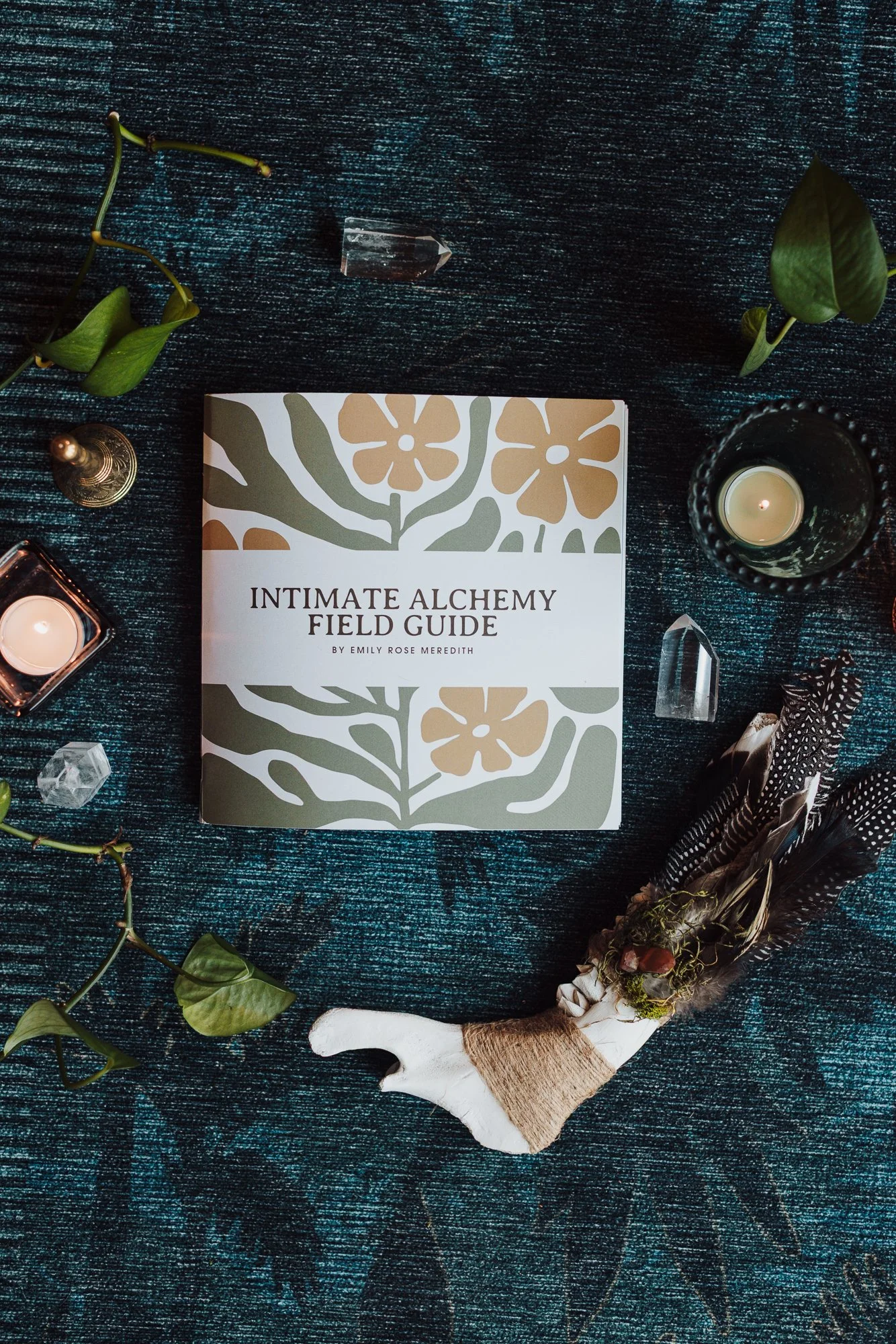 Intimate Alchemy Workbook for journaling prompts on overwhelm and shutdown, on blue rug surrounded by leaves