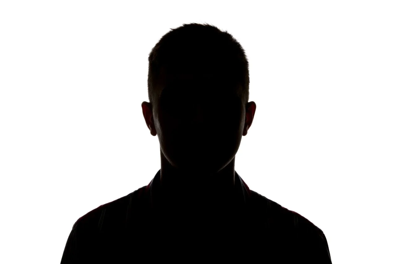 Silhouette of a person with short hair against a white background.