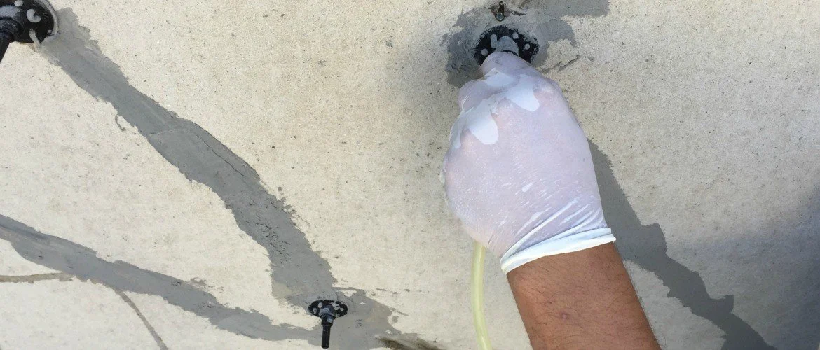 A person wearing a white glove is fixing or inspecting a ceiling water leak with a tube or hose.