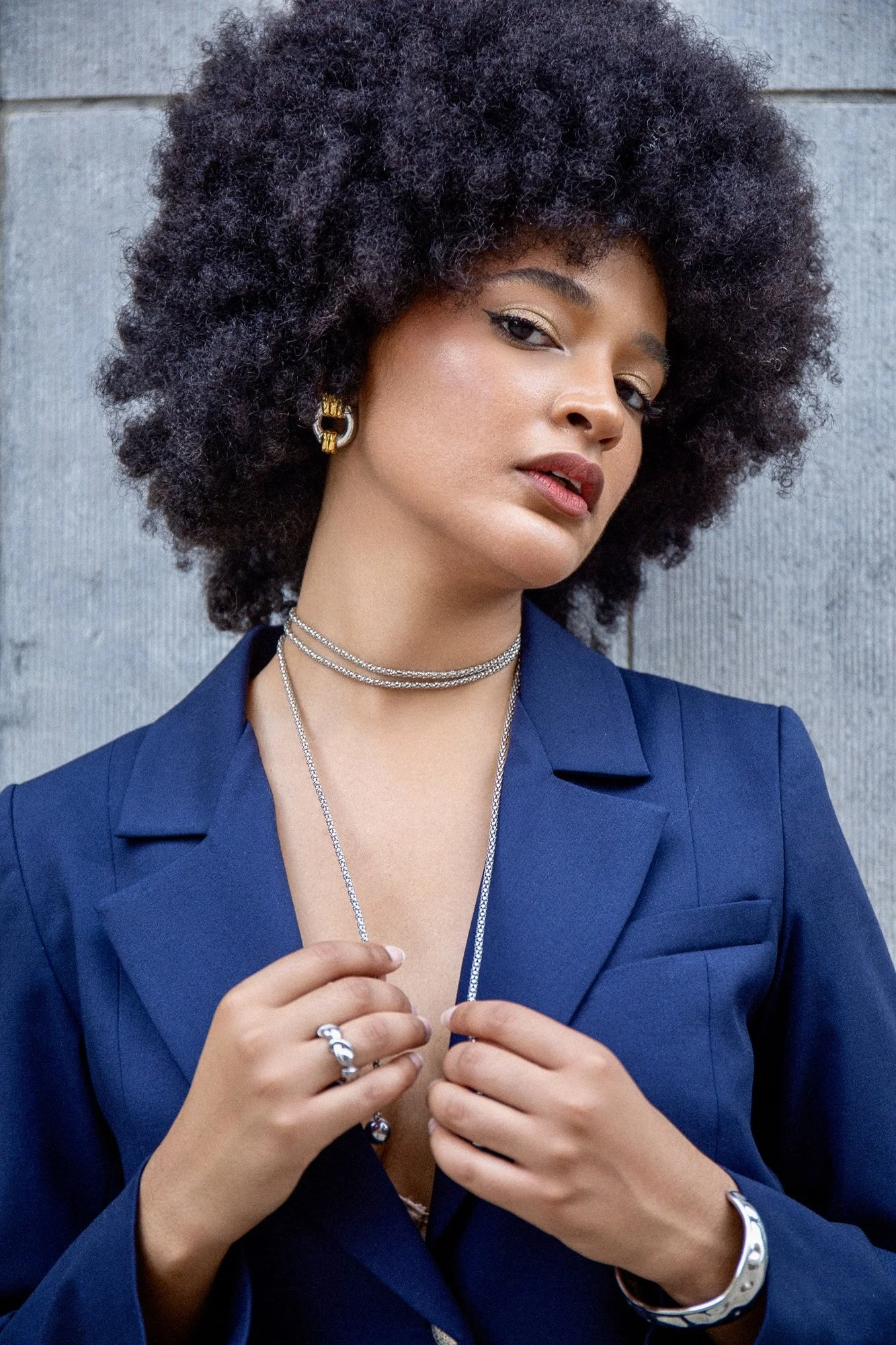Editorial fashion portrait of model Ana wearing a vibrant blue tailored blazer by Francini_K, complemented by delicate Ennomerato jewelry. Photographed by Henri Da Cruz in Luxembourg, highlighting elegant styling, refined jewelry details and contempo