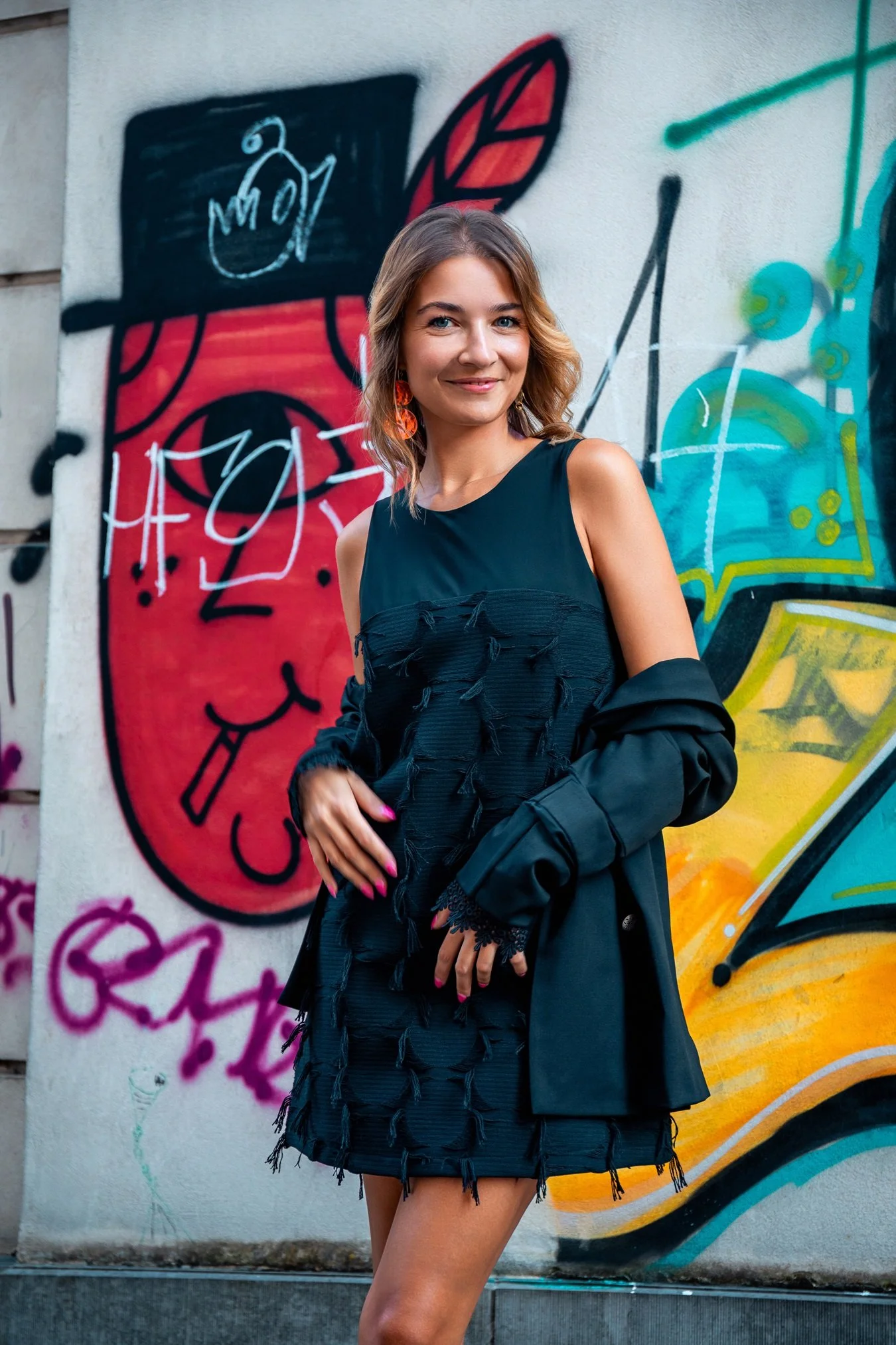 Editorial fashion portrait in Luxembourg City, combining a contemporary black look with a colorful urban backdrop, photographed by Henri Da Cruz.