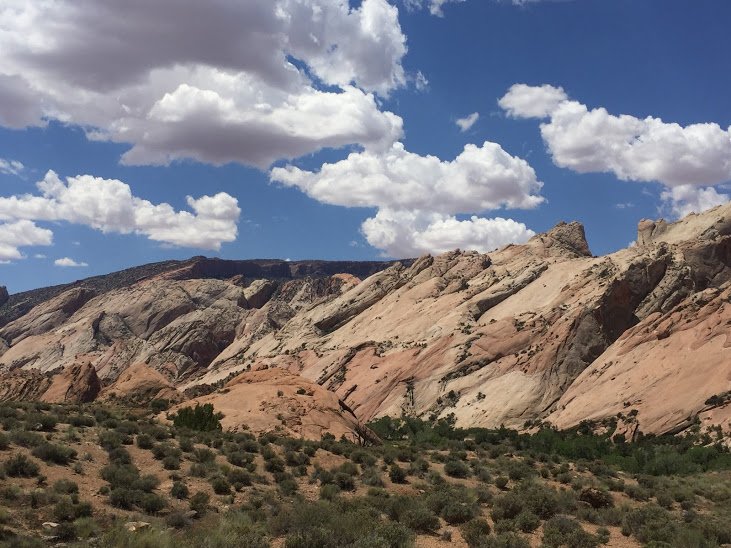 Colorful rocky mountains beneath a partly cloudy sky