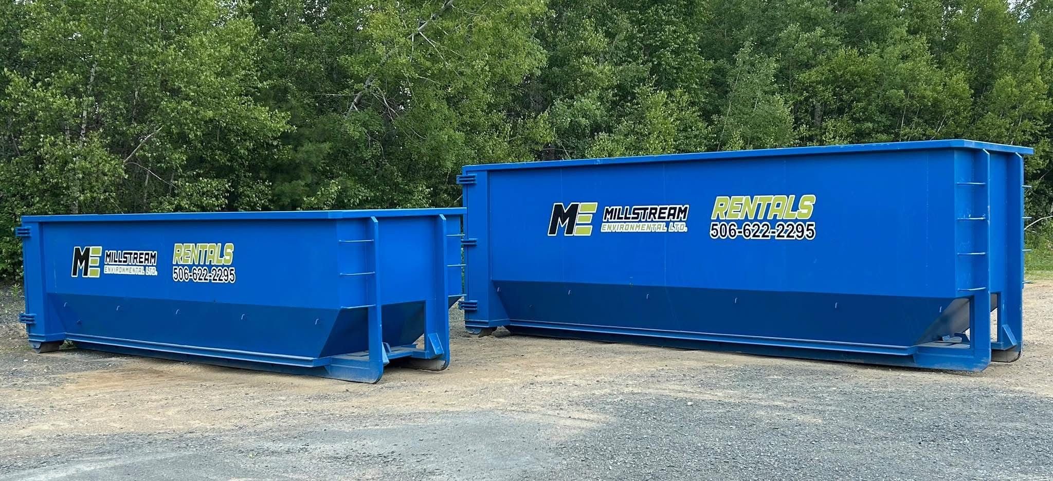 Two blue recycling containers with the logo and contact information for Millstream Environmental Ltd., placed on gravel with green trees and foliage in the background.
