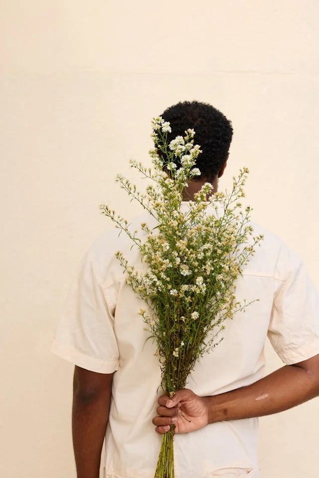 A man holding wildflowers