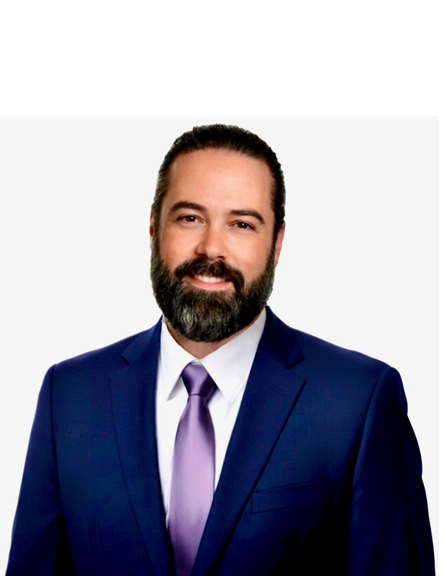 Smiling man with dark hair, beard, and mustache wearing a navy blue suit, white shirt, and purple tie against a light background.