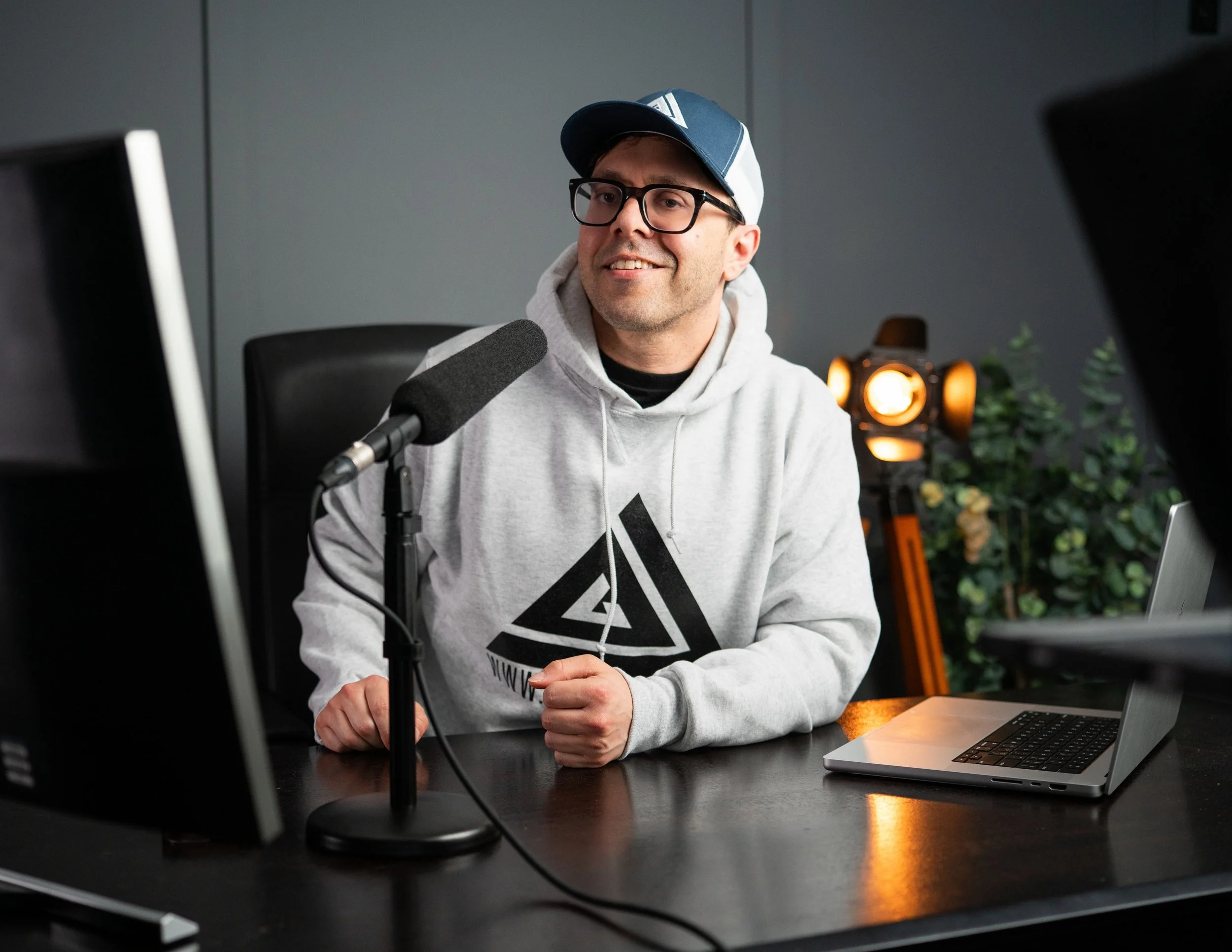 Jeff Gordon, founder of JAG Creator Academy, speaking into a microphone in a professional studio while teaching photography, videography, lighting, editing, and content creation.