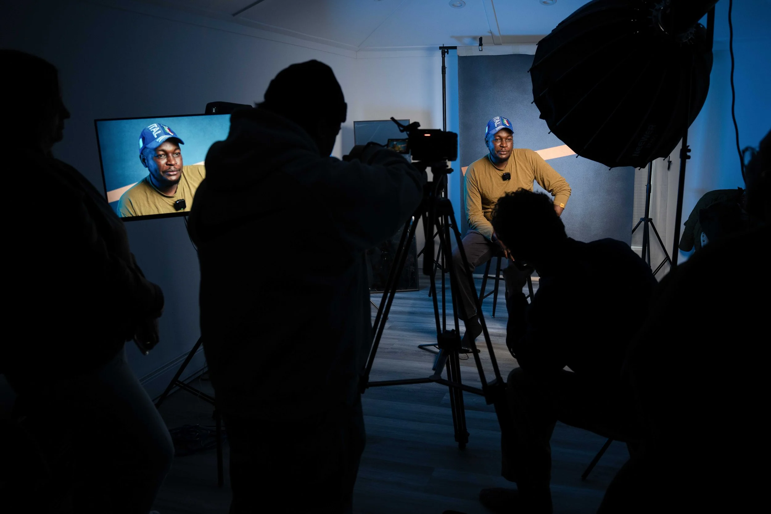 Group of photography students practicing natural light portrait photography with studio light and a canvas backdrop during a hands-on digital photography course.