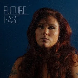Suzanne Sheer with long red hair, looking at the camera with a serious expression, against a dark background, with the words 'FUTURE PAST' in the upper left corner.