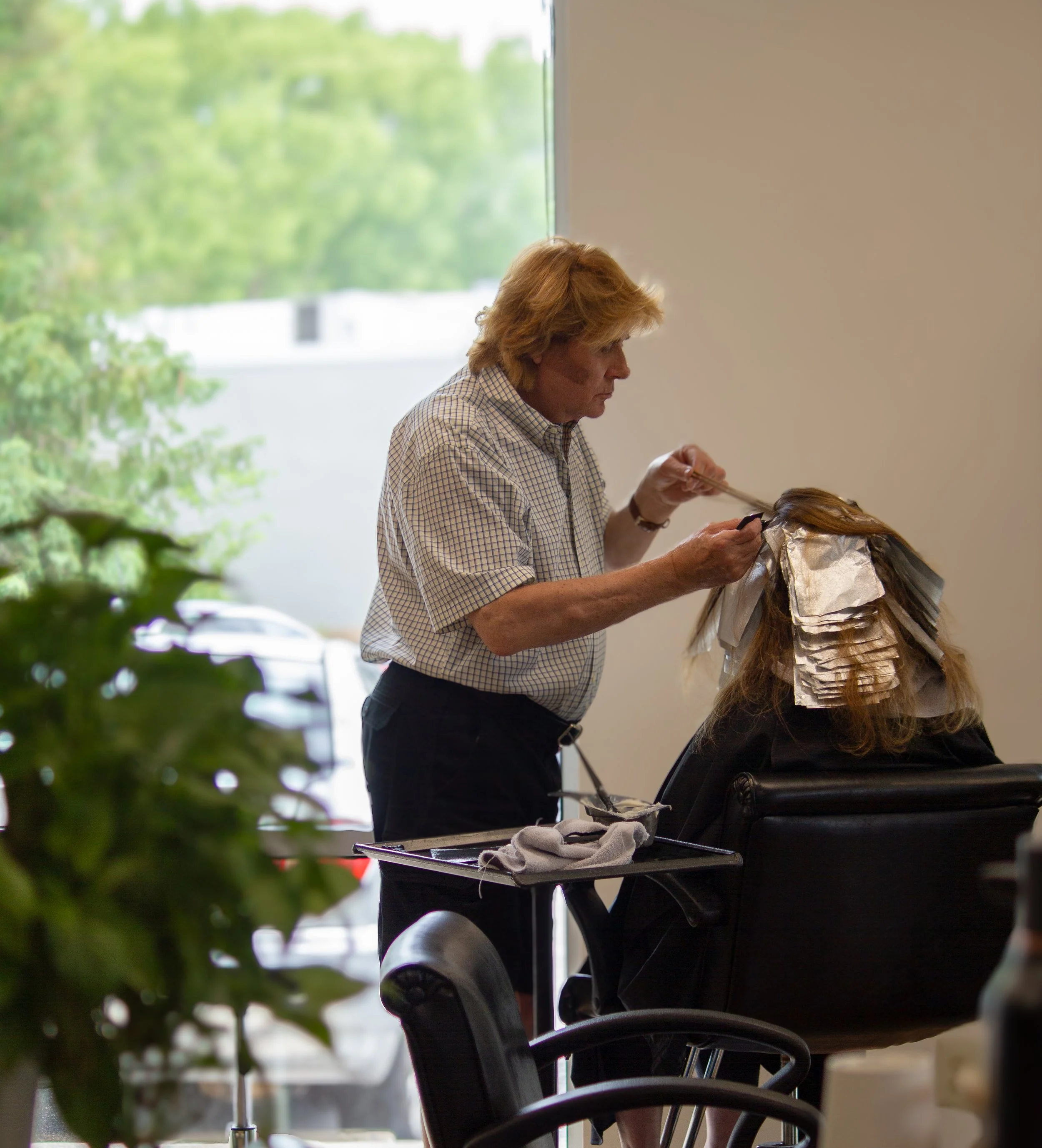 David, hair stylist at Prestige Salon in Wayne pa, doing highlights on a client
