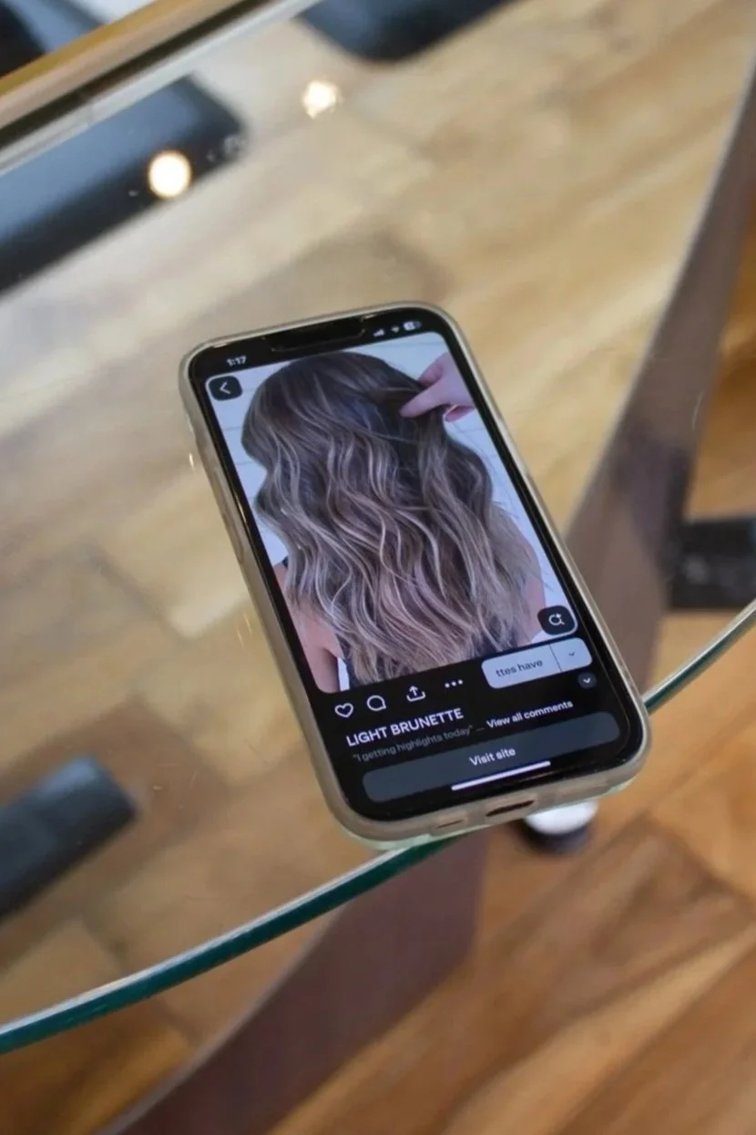 A Phone showing a picture of light brunette hair for an inspiration hair.