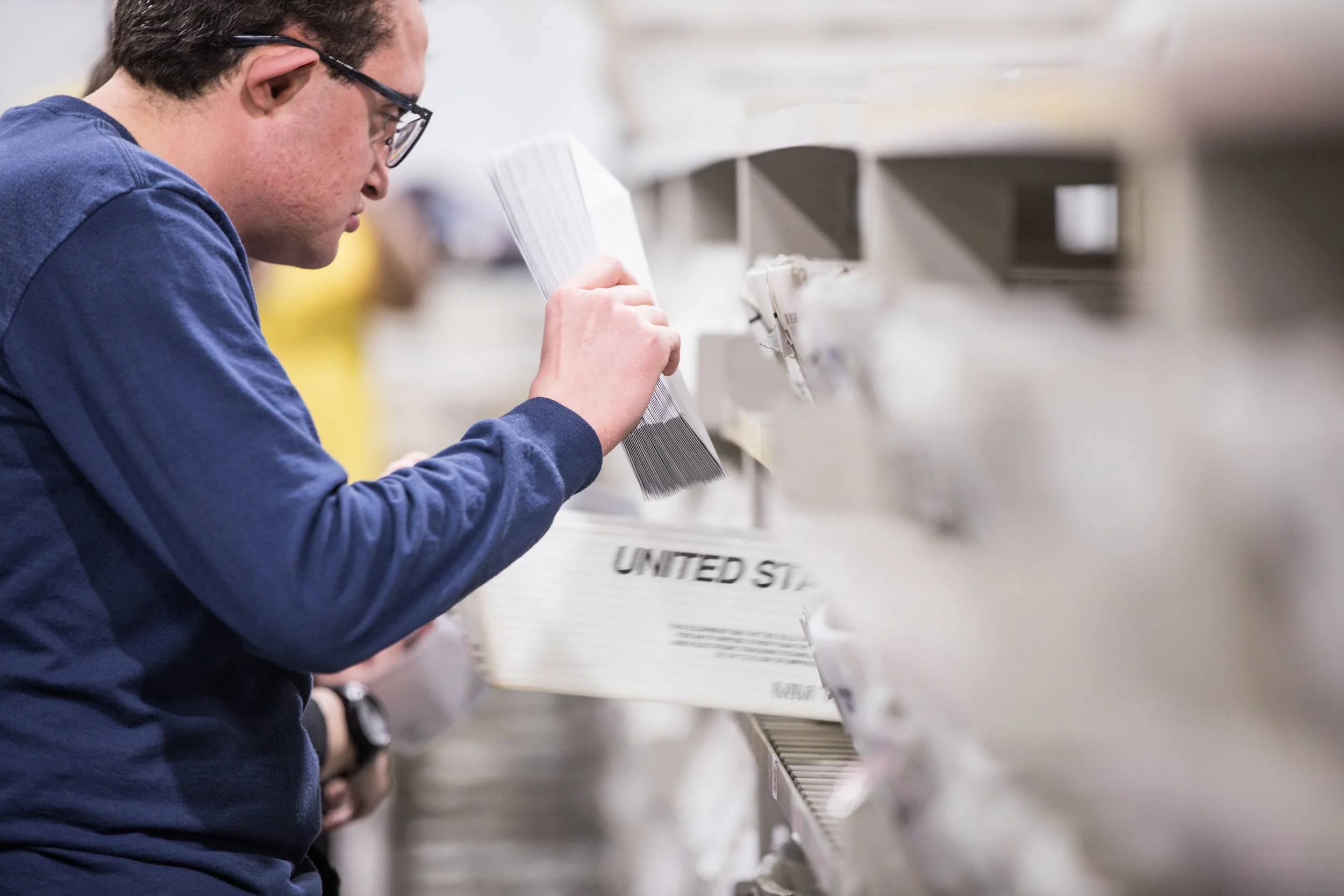 A Tandem Solutions worker sorting mail in a facility.
