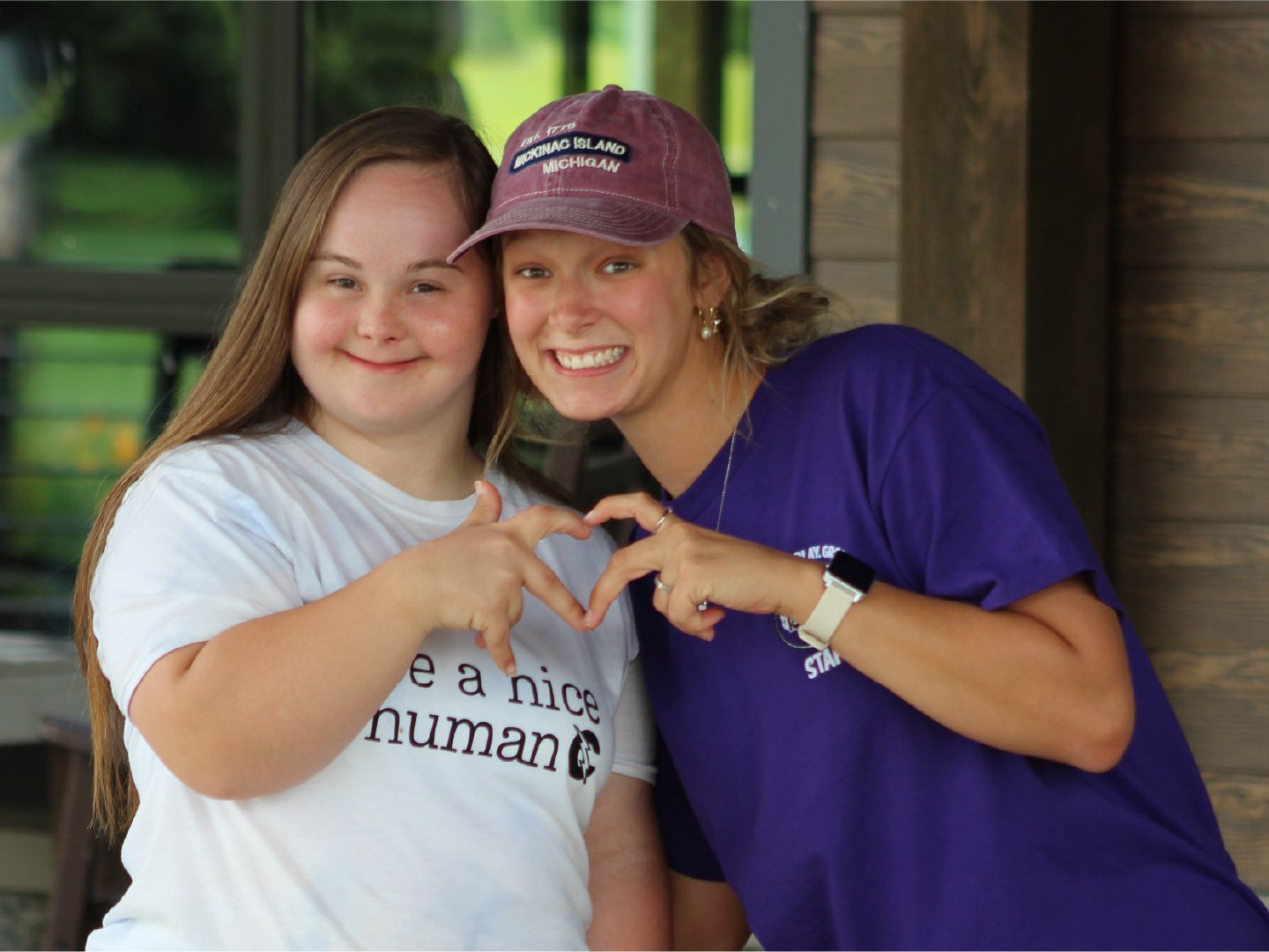 A Camp Red Cedar volunteer staffer with a young woman with Down Syndrome having fun at camp.
