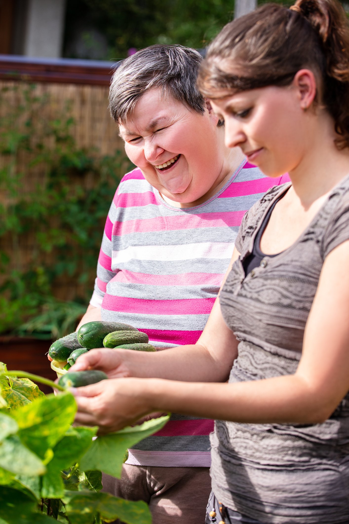 Image of a women in one of AWRC's Georgia transitional homes working in a garden with a staffer.