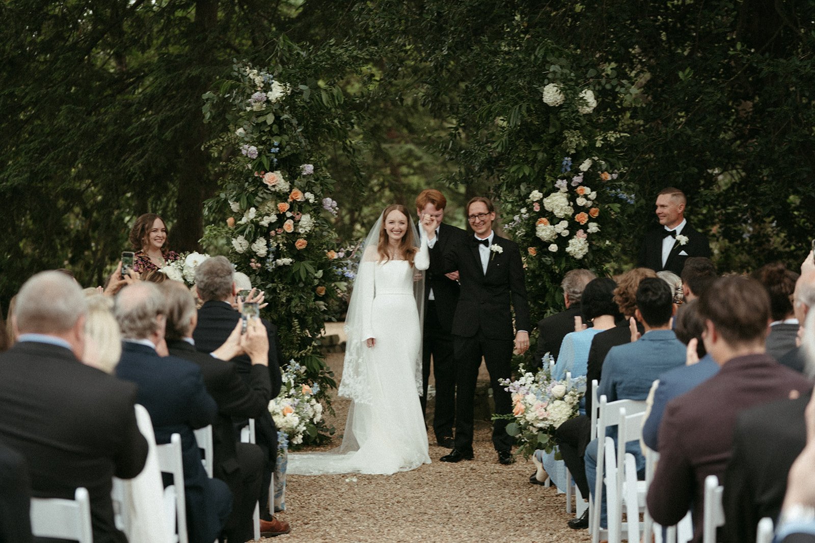  A couple in wedding attire walks down the aisle after their ceremony at the VanLandingham Estate in Plaza Midwood, North Carolina 
