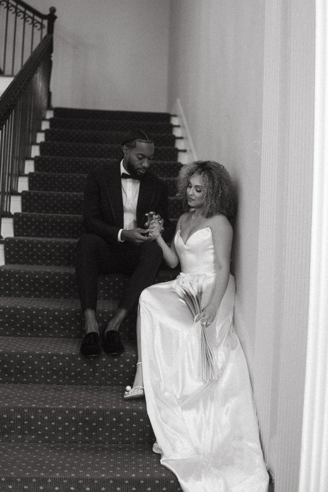 A black and white image of a bride and groom on the steps at The Duke Mansion