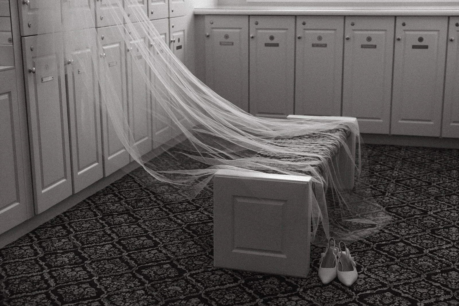 a black and white image of a veil and wedding shoes