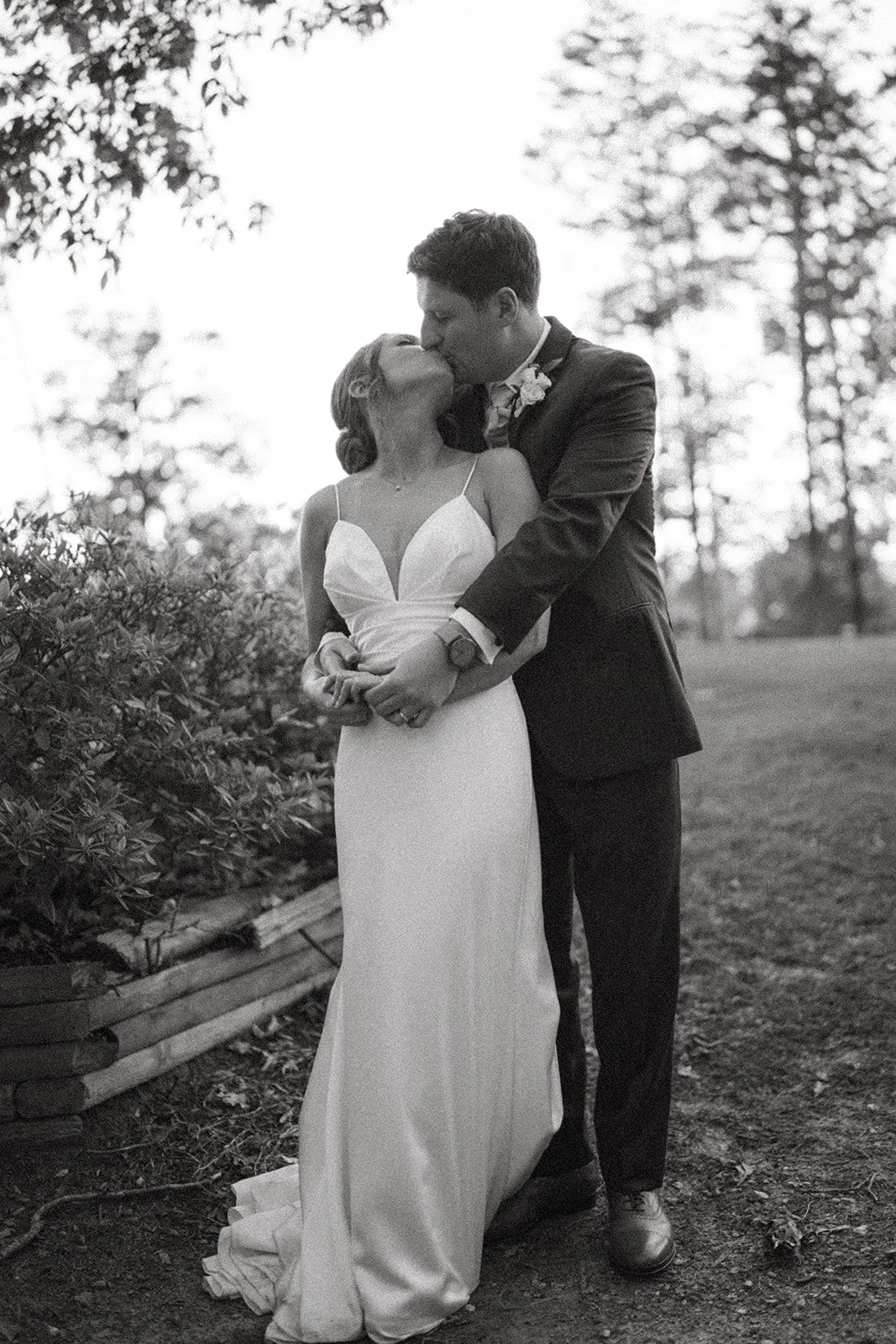 black and white image of a bride and groom kissing