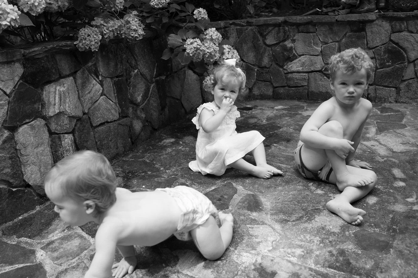 Three siblings in a black and white photo