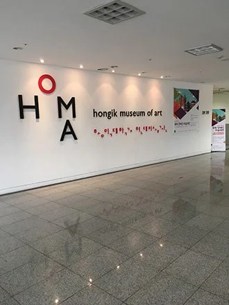 Interior wall of the Hongik Museum of Art with the museum's name and logo. exhibited in Seoul Korea. Sergio de Luz.