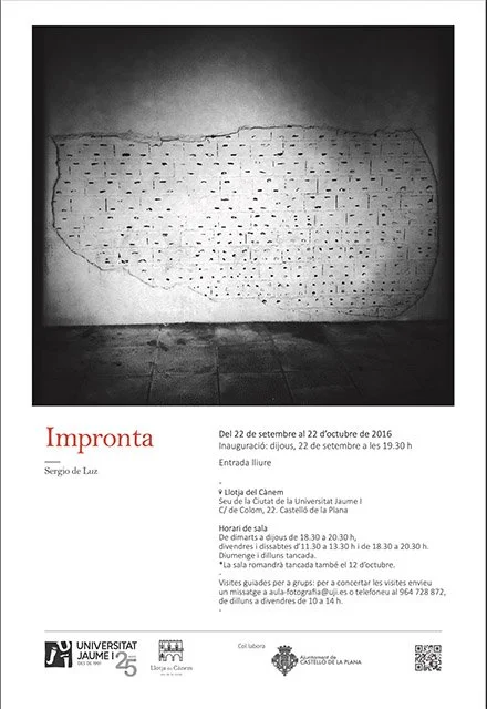 Black and white poster with a large, irregularly shaped pattern of small, evenly spaced holes in the center. This pattern resembles a perforated wall or panel against a plain background.