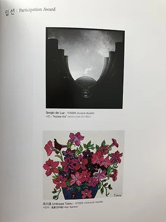 Two artworks on a white background: the top piece is a black-and-white photo of a curved structure with a moonlit sky, labeled 'Serio de la Luna'; the bottom piece is a colorful illustration of pink and red flowers with green leaves.exhibited in Seou