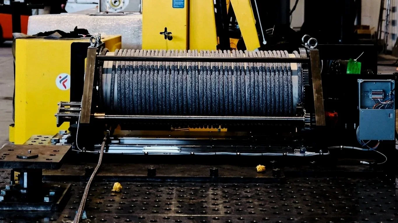 Un dispositivo meccanico complesso con rotori e ingranaggi, probabilmente parte di una macchina o di un sistema di produzione, su un banco di lavoro industriale.