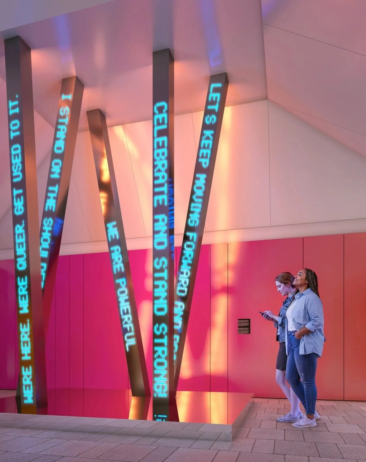 Two women look at a light sculpture in a gallery.