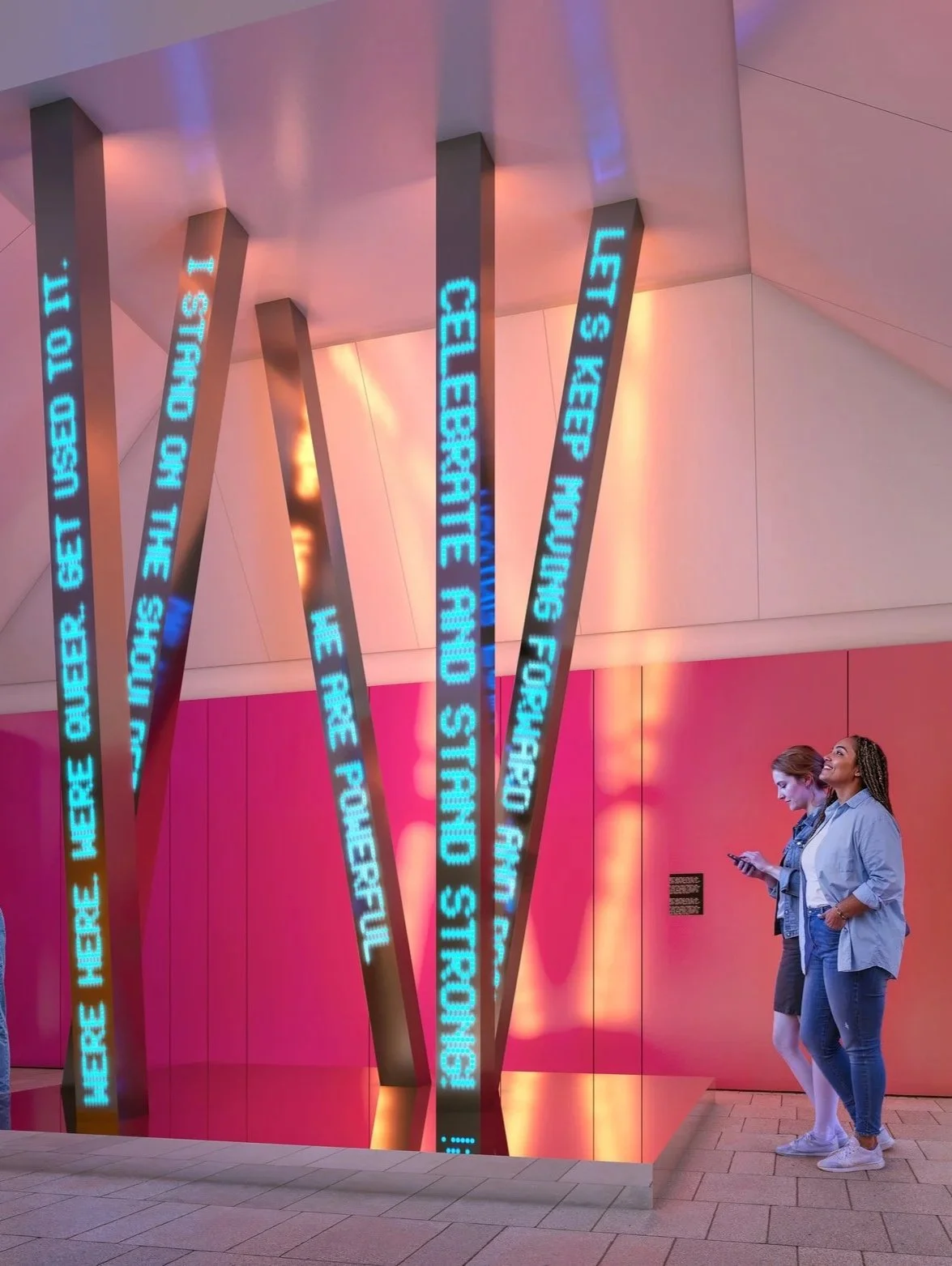 Two women look at a sculpture inside a gallery.