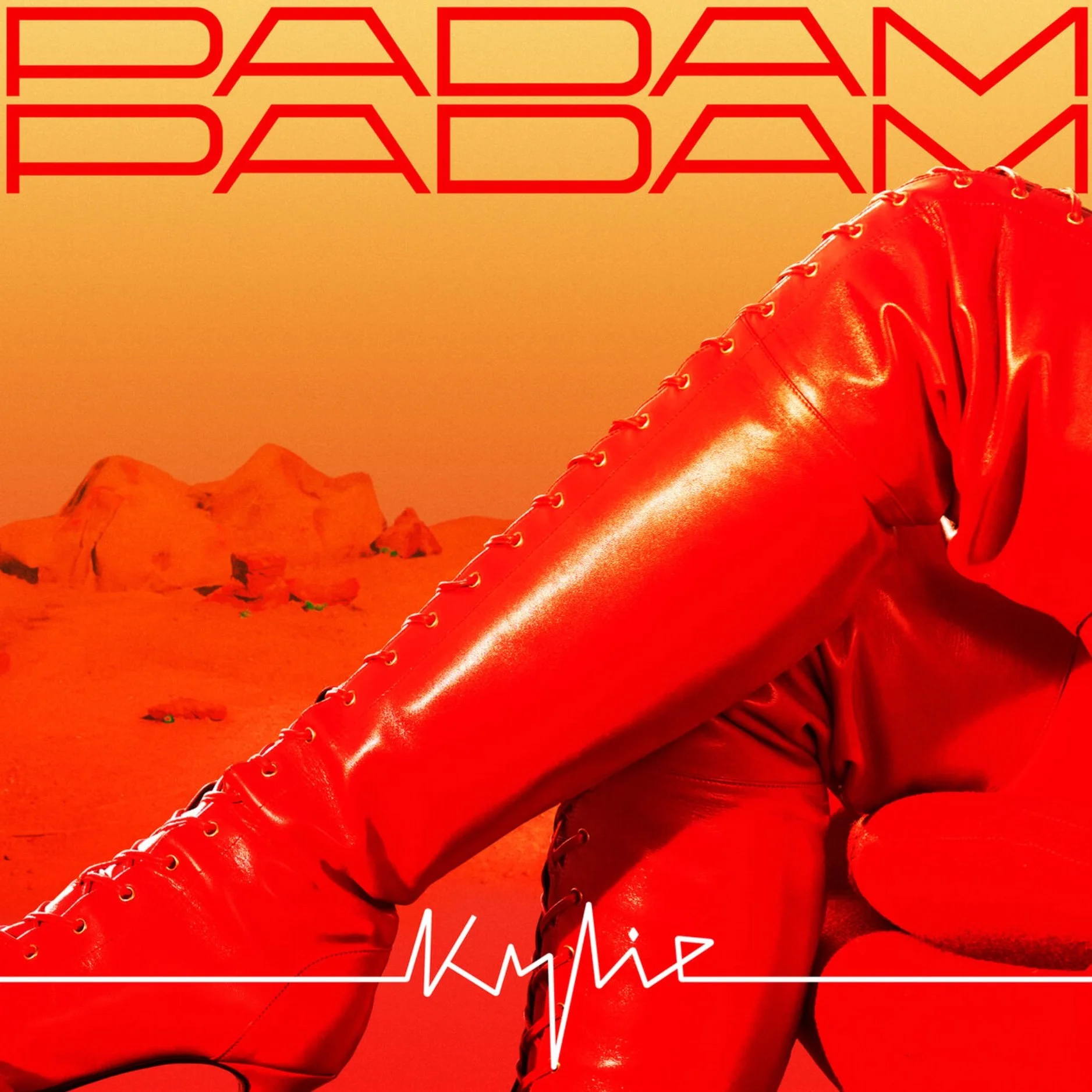 Close-up of a person wearing red leather pants and red lace-up boots, with mountain landscape background, and stylized red text reading 'PADAM PADAM' at the top. The word 'KAMUI' appears at the bottom.