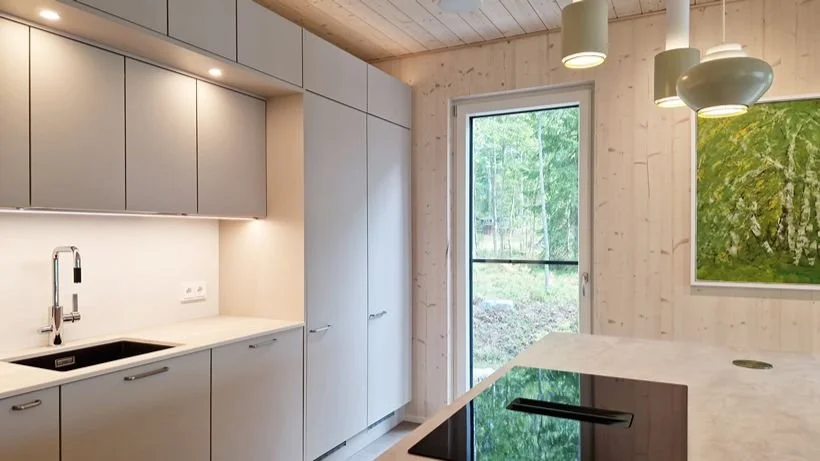 Vaalea keittiö kivitasot clt-seinät riippuvalaisimet
