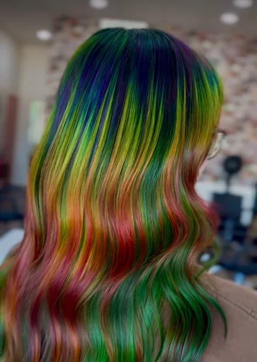 Colorful rainbow hair with shades of blue, green, yellow, orange, and pink styled in loose waves.
