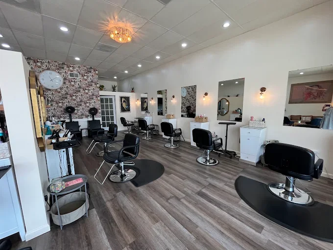 Interior of a modern hair salon with multiple styling chairs, mirrors, and salon equipment.