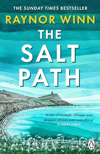 Book cover of 'The Salt Path' by Raynor Winn, showing a coastal landscape with cliffs, water, and a small building in the distance.