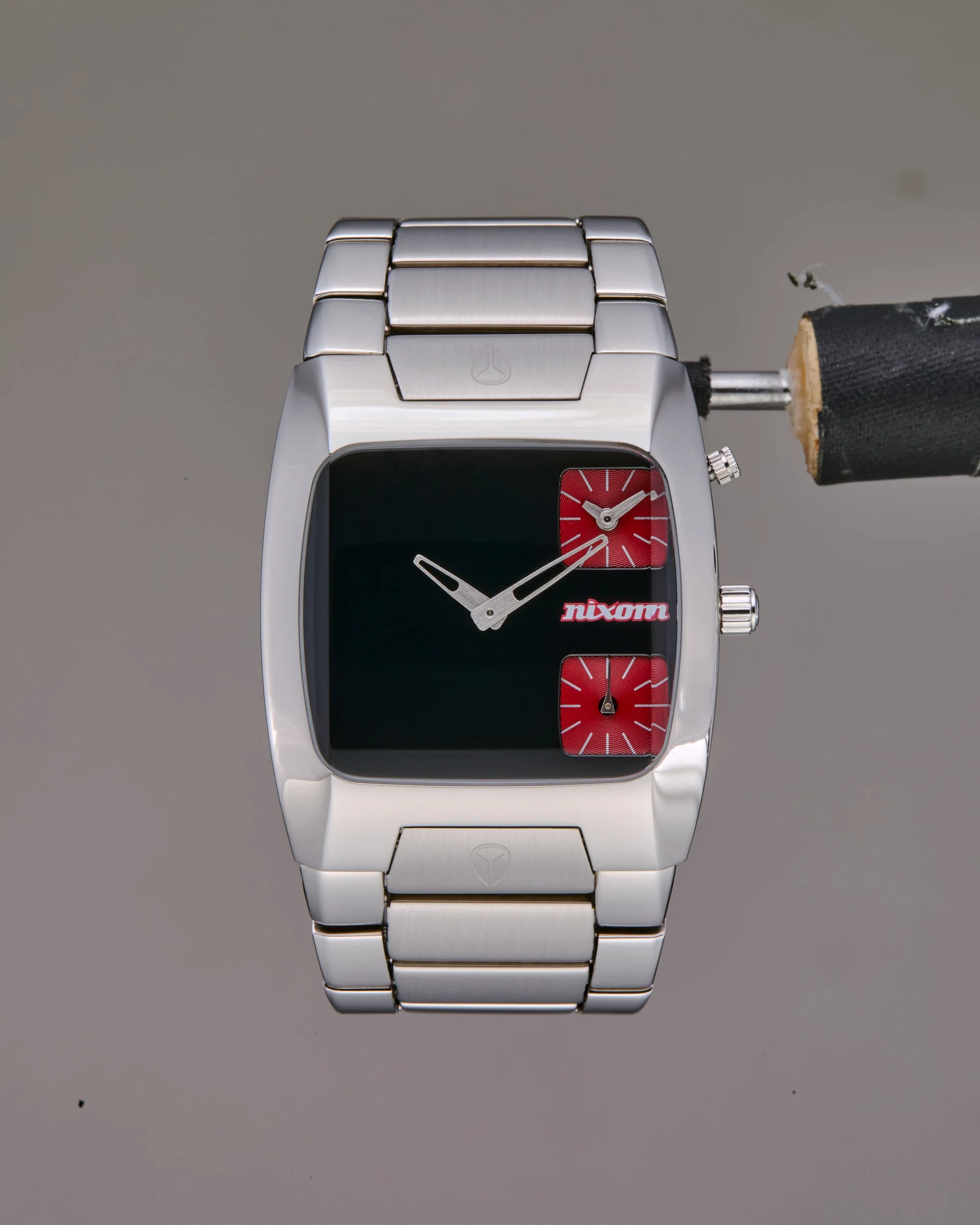 Original photo of a silver wristwatch with black and red accents, displaying the time, featuring a metal band and a rectangular face.