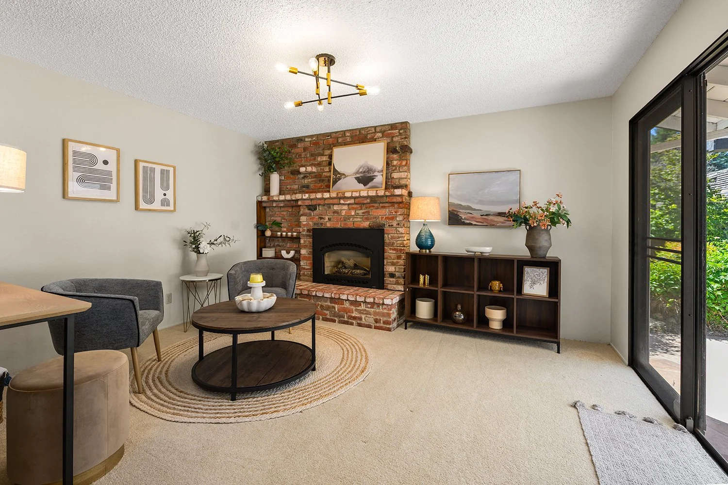 Living room with brick fireplace, gray and beige furniture, and decorative artwork.
