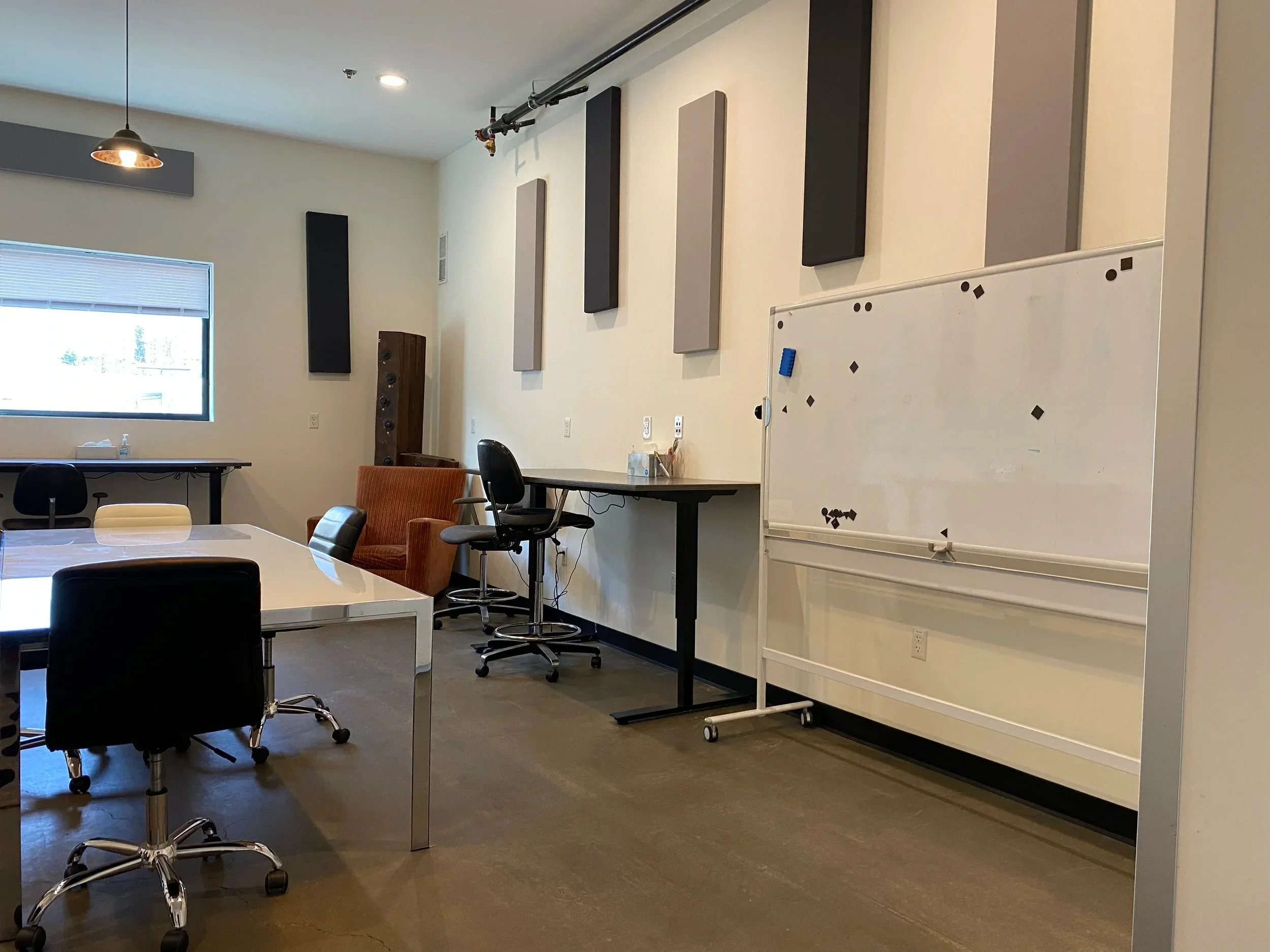 A spacious production office with a large table and multiple workstations.