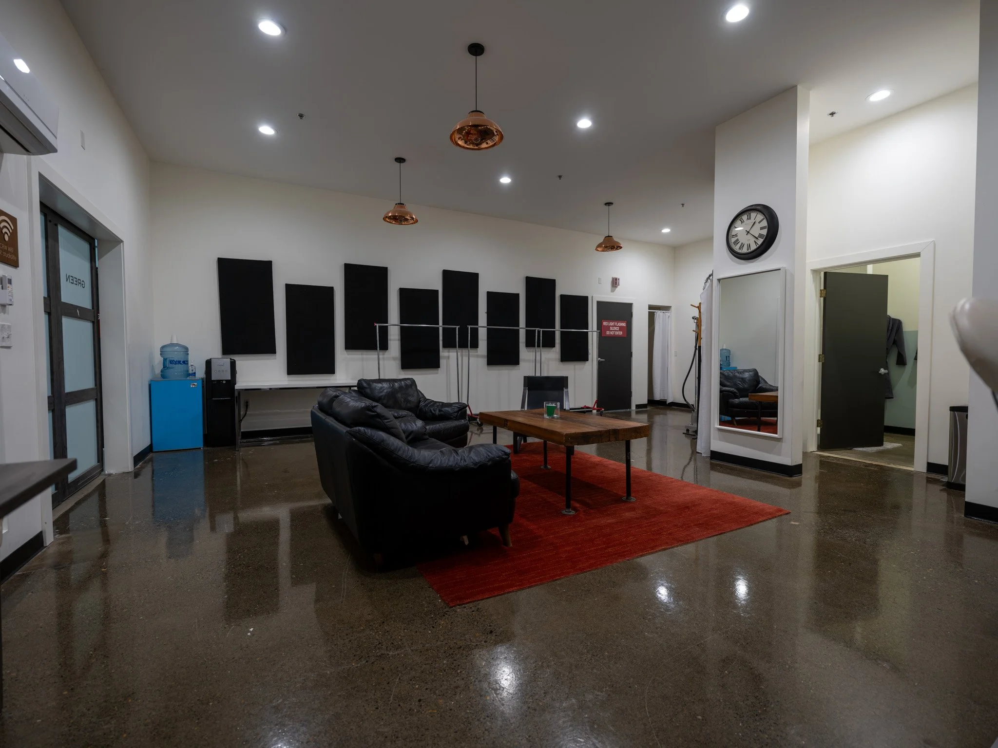 Hair/Makeup/Green Room with 2 styling stations, private full bathroom with shower, casual seating arrangement and plenty of space for wardrobe racks
